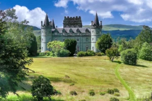 Front façade of Inveraray Castle framed by gardens and rolling hills