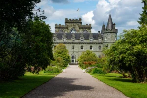 Front path leading to Inveraray Castle framed by manicured gardens and trees.