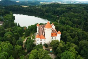 Aerial view of Konopiste Castle surrounded by forest and lake