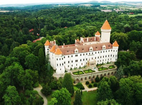 Aerial view of Konopiste Castle surrounded by dense green forest