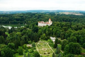Aerial view of Konopiste Castle surrounded by dense forest and formal gardens