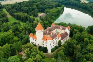 Aerial view of Konopiste Castle amid forest and lake