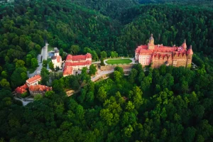 Aerial view of Ksiaz Castle surrounded by dense green forest
