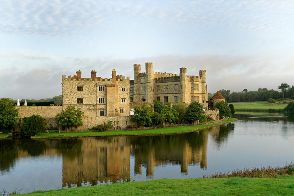 Leeds Castle reflected in calm moat and green lawns