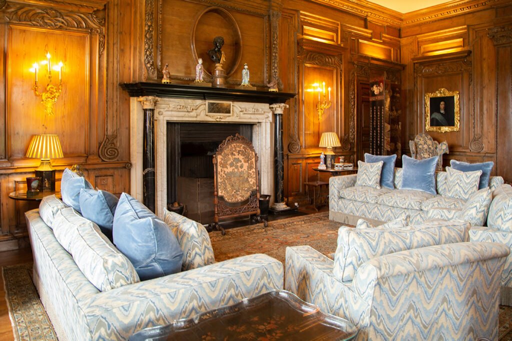 Leeds Castle wood-paneled drawing room with sofas and fireplace