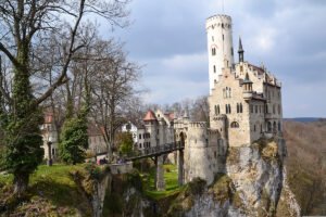 Lichtenstein Castle perched on rocky cliff with wooden bridge and tall tower