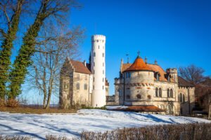 Lichtenstein Castle perched on a snowy hill under blue winter sky