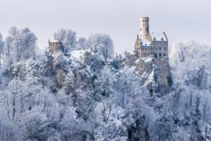 Lichtenstein Castle perched on snow-covered cliff amid frosted trees