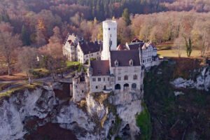 Aerial view of Lichtenstein Castle perched on limestone cliff in autumn woods
