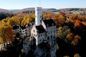 Aerial view of Lichtenstein Castle perched on rocky cliff among autumn trees
