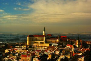 Mikulov Castle on hill above snow-dusted town at golden hour