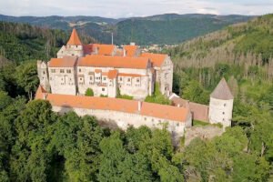 Aerial view of Pernstejn Castle on wooded hilltop