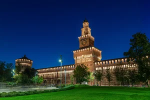 Sforzesco castle illuminated at night with central tower and surrounding walls