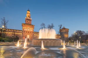 Sforzesco Castle with illuminated fountain at twilight