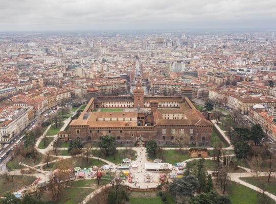 Aerial view of Sforzesco Castle surrounded by Milan rooftops
