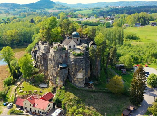 Aerial view of Sloup Castle atop sandstone cliffs