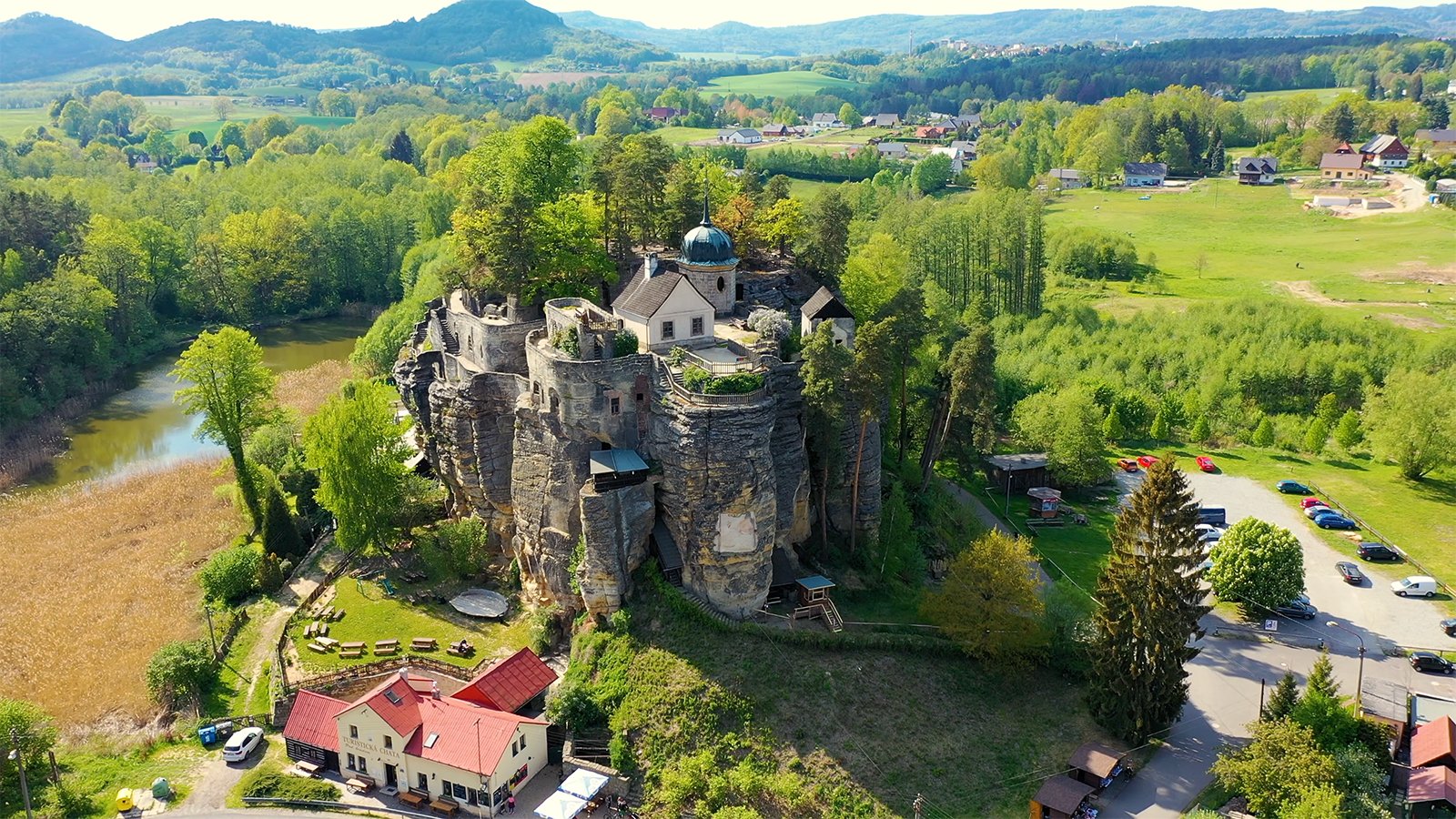 Aerial view of Sloup Castle atop sandstone cliffs