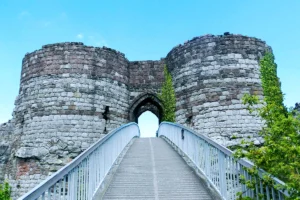 Stone gate and round towers of Beeston Castle seen from bridge