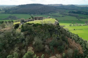 Beeston Castle ruins atop rocky crag overlooking green Cheshire fields