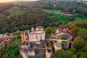 Aerial view of Bonaguil Castle perched above forested valley