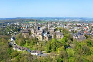 Aerial view of Braunfels Castle perched above a green hill with town below