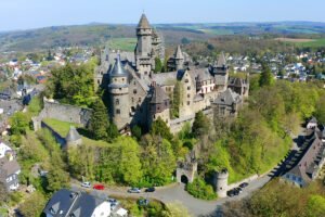 Aerial view of Braunfels Castle perched above town and forested slopes