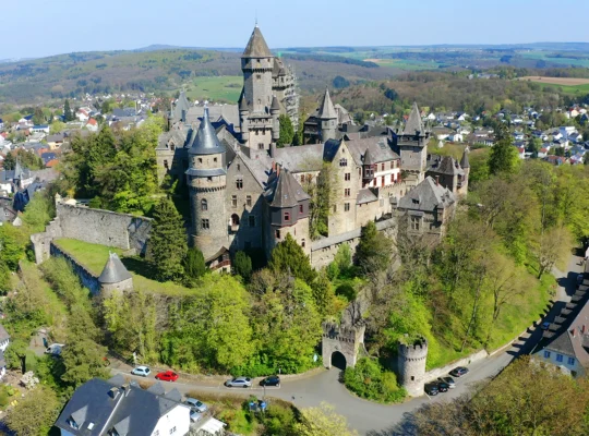 Vista aérea del castillo de Braunfels sobre colina boscosa y pueblo