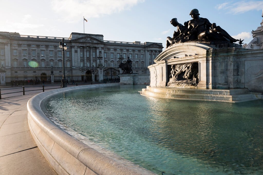 Buckingham Palace facade and fountain at sunny late afternoon