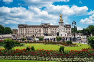 Buckingham Palace facade seen from flowered garden under blue sky