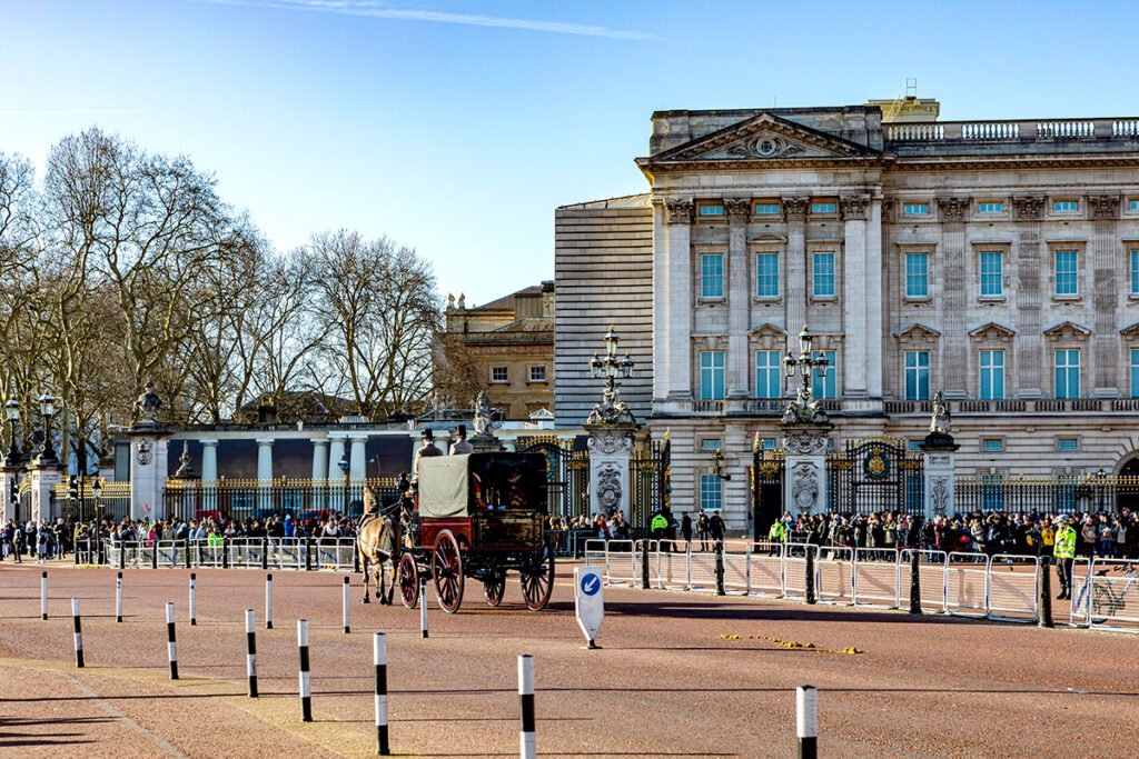 Buckingham Palace façade with horse carriage and crowd