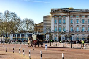 Buckingham Palace façade with horse carriage and crowd
