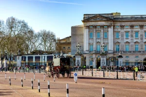 Buckingham Palace façade with horse carriage and crowd