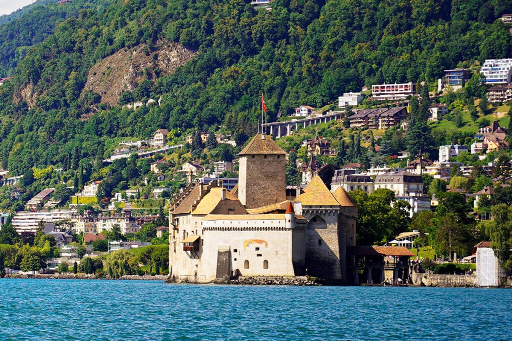 Chillon Castle on lakeshore with mountains in background