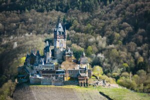 View of Cochem Castle perched above Moselle vineyards and forested hillside