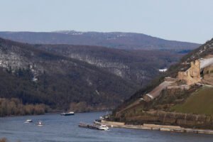 Ehrenfels Castle on hillside above the Rhine, cargo ships passing
