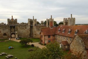 Framlingham Castle courtyard with medieval walls and red-tiled manor, overcast sky