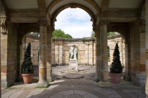 Hever Castle stone arcade framing central classical statue in circular garden