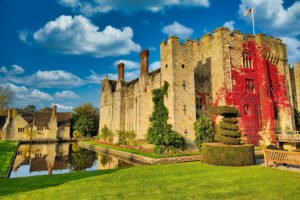 Hever Castle beside reflective moat and autumn ivy-covered stone walls