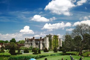 Hever Castle with manicured gardens under a bright blue sky