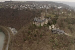 Aerial view of Lahneck Castle on wooded hill above the Rhine