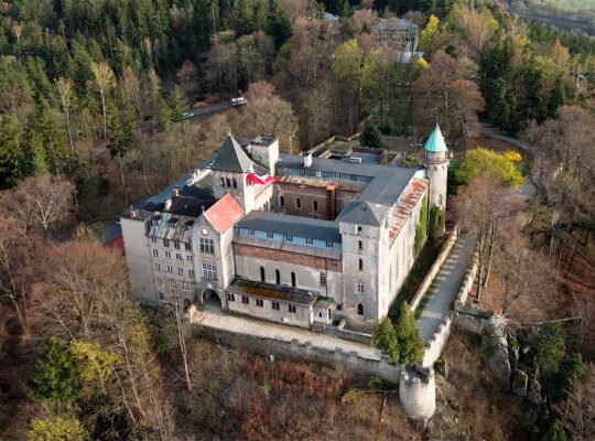 Aerial view of Lesna Skala Castle amid forested hills