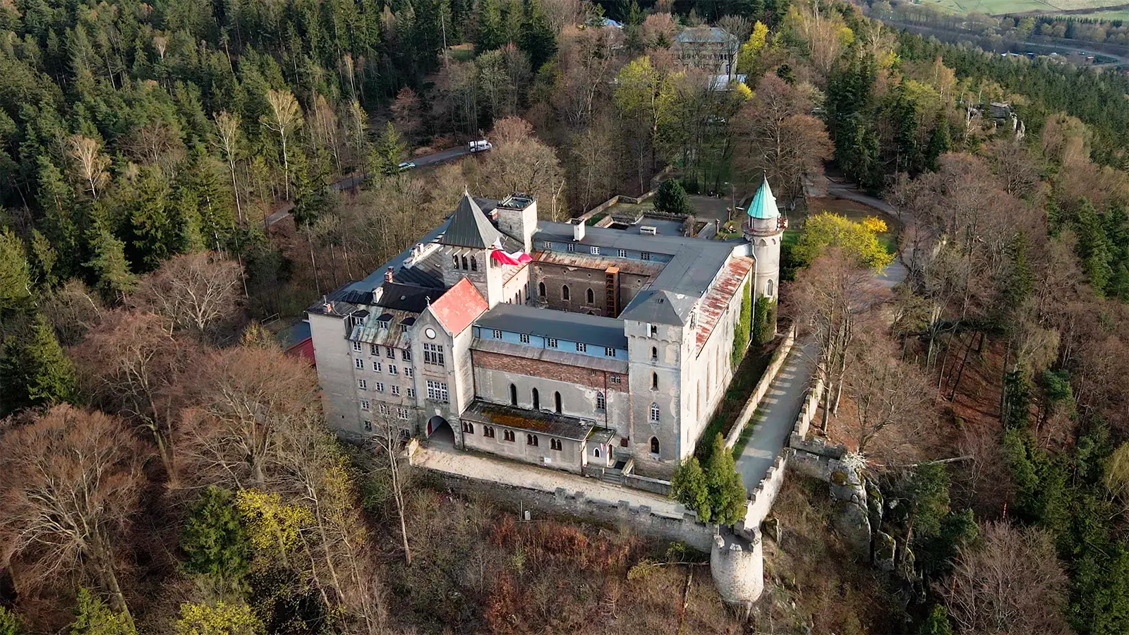 Aerial view of Lesna Skala Castle amid forested hills