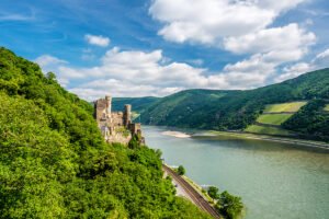Rheinstein Castle perched above the Rhine with forests and river valley