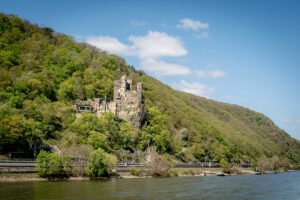 Rheinstein Castle perched on rocky hill beside the Rhine river