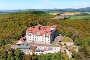 Aerial view of Bieberstein Palace, Hesse surrounded by forested hills and farmland