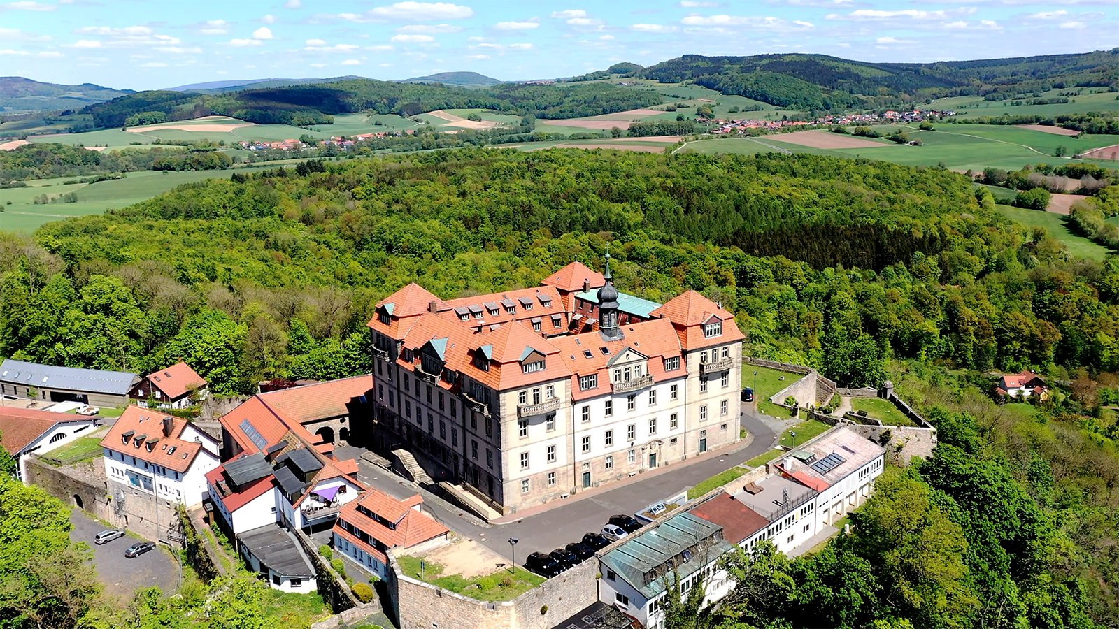 Aerial view of Bieberstein Palace, Hesse atop forested ridge