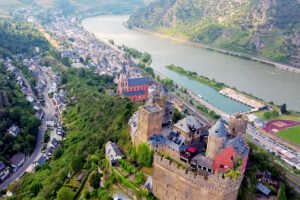 Aerial view of Schönburg Castle atop hill beside the Rhine and village