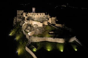 Aerial night view of Spiš Castle lit on hilltop