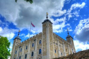 The Tower of London stone keep under dramatic blue sky