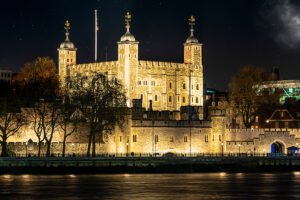 The Tower of London illuminated along River Thames at night
